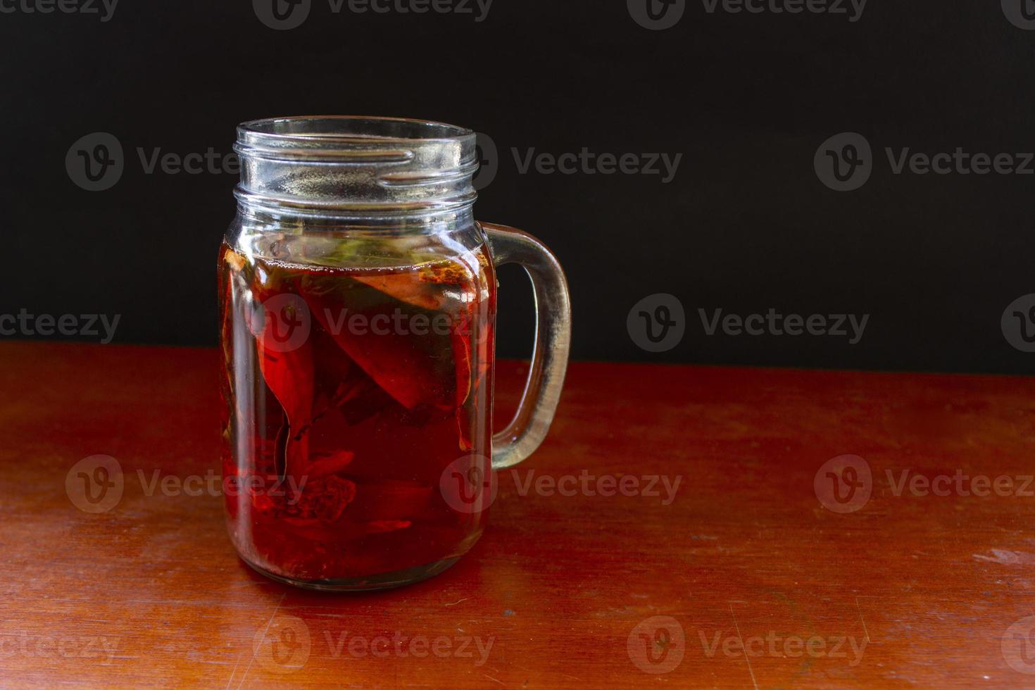 wedang uwuh is traditional herbal drink from indonesia. made from cinnamon, nutmeg and cloves leaves. Another ingredient is wood from the secang tree, ginger and lump sugar on black background photo