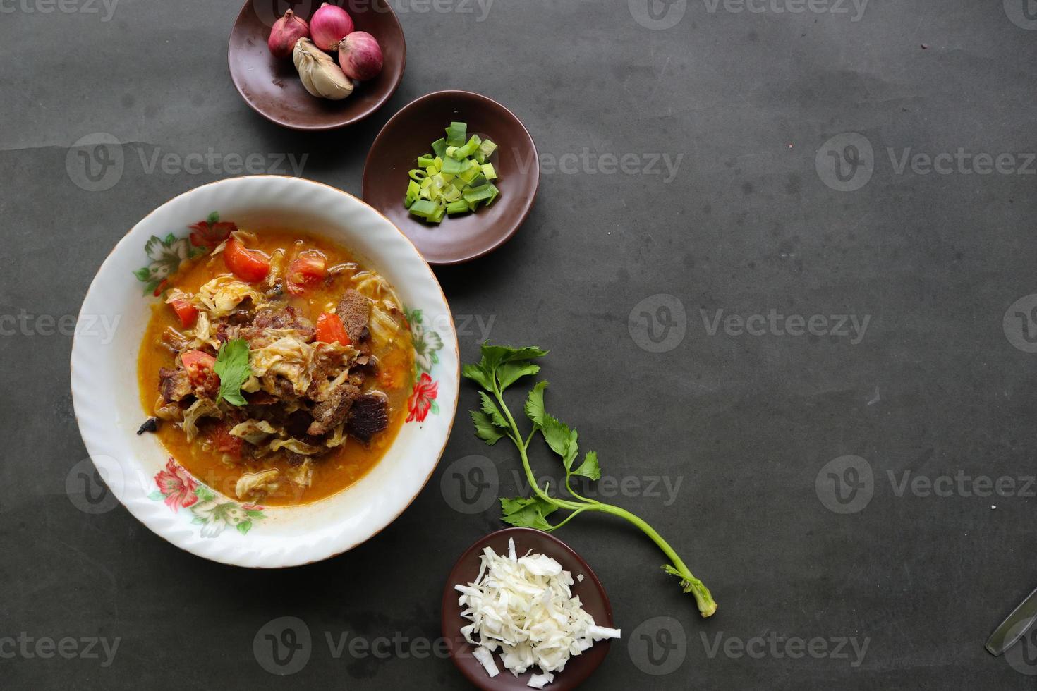 Goat Curry or gulai kambing, food from asia. Delicious goat meat curry served in a bowl.served with tomato, seasoning, celery and cabbage photo