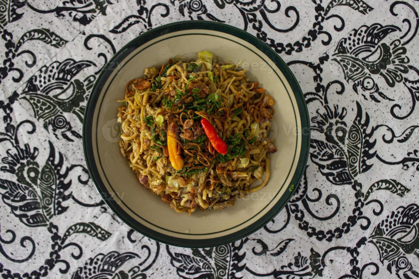 Mie Goreng Jawa or bakmi jawa or java noodle with spoon and fork. Indonesian traditional street food noodles from central java or Yogyakarta, indonesia on white background photo