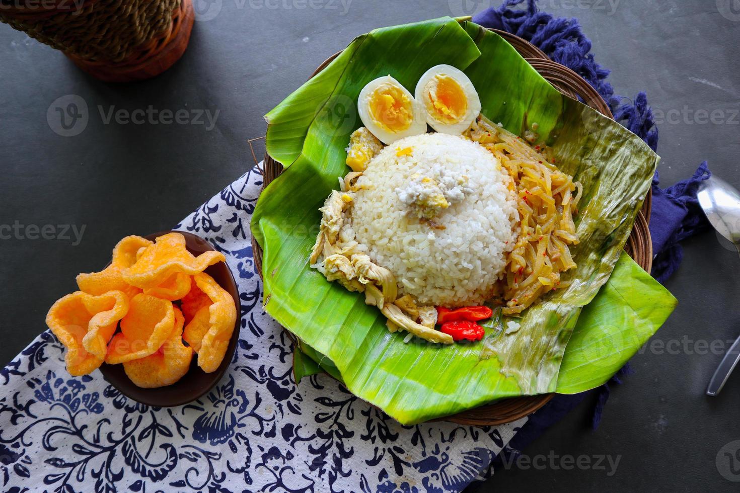 Nasi Liwet Solo or Sego Liwet Solo is a traditional food from Surakarta. made from savory rice, chayote and boiled egg, chicken, thick coconut milk served on a banana leaf photo