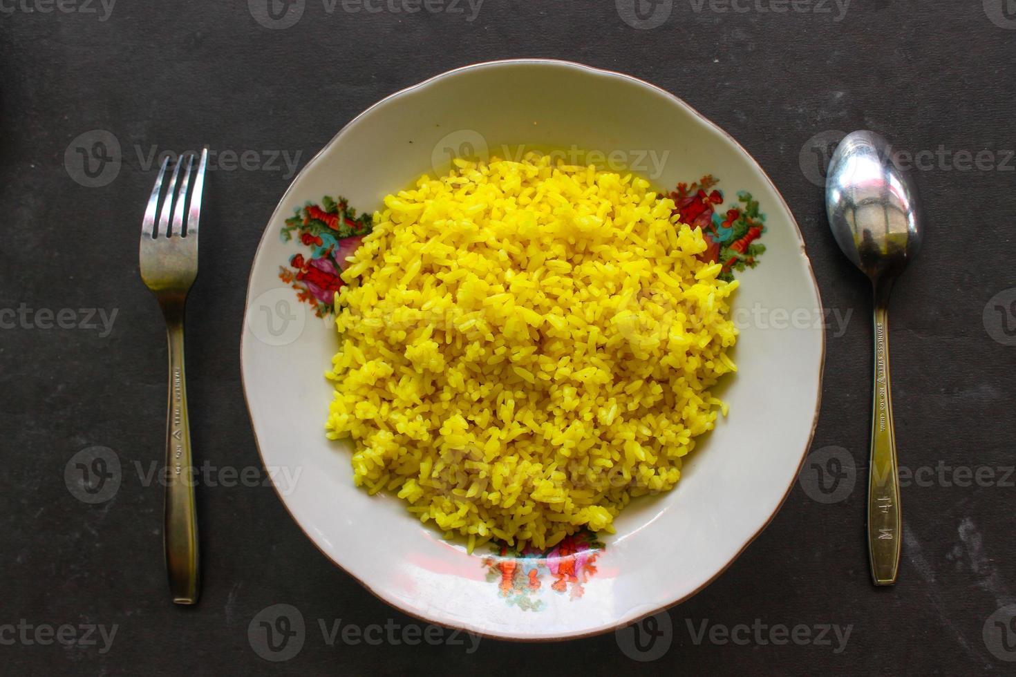 yellow rice or turmeric rice or nasi kuning is food made from rice cooked with turmeric, coconut milk and spices. so the taste is more savory photo