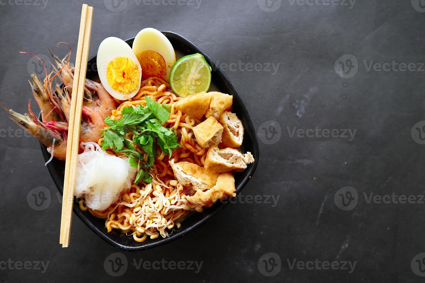 laksa, laksa curry made from vermicelli, noodles, bean sprouts, egg, tofu lime, and shrimp with a spicy soup sauce that is rich in spices. laksa served on bowl, isolated on white background. photo