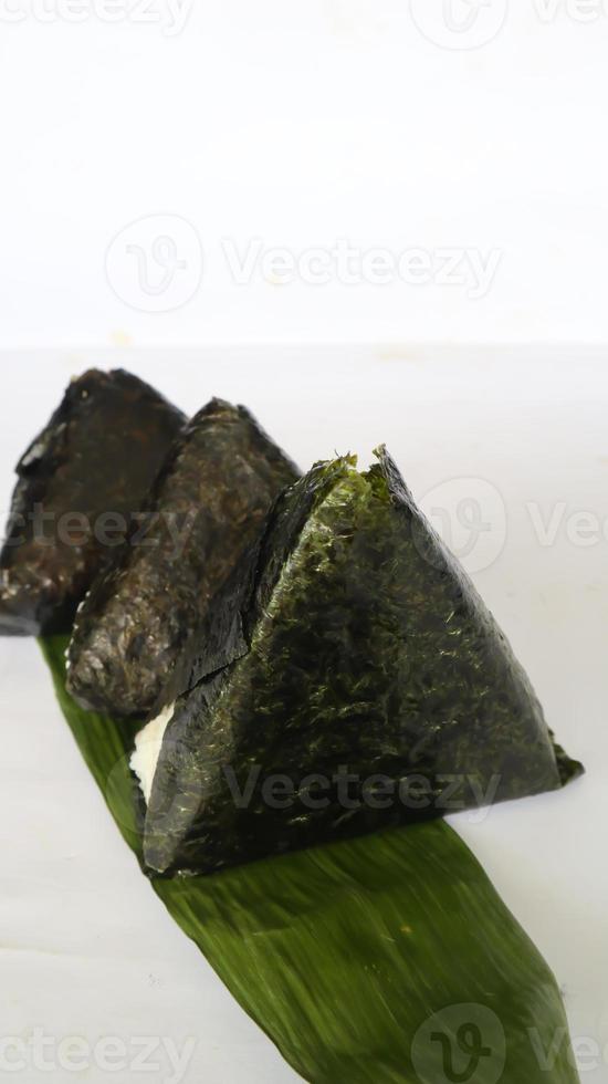 onigiri es comida japonesa, bola de arroz japonesa, triángulo de arroz con algas, nori aislado con fondo foto