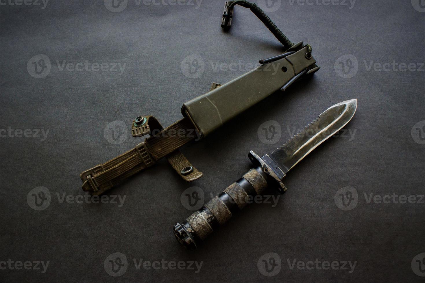 dark black military knife on black background photo