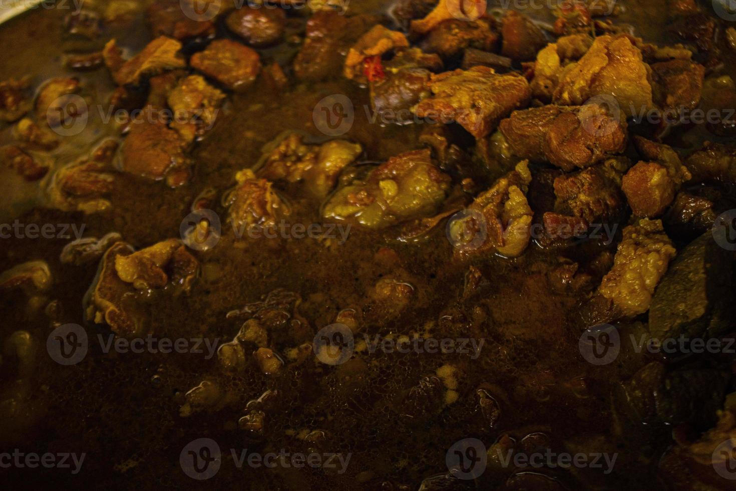 Traditional cooking raw meat with yellow curry or Tongseng in pan. Tongseng is traditional curry food from central java indonesia photo