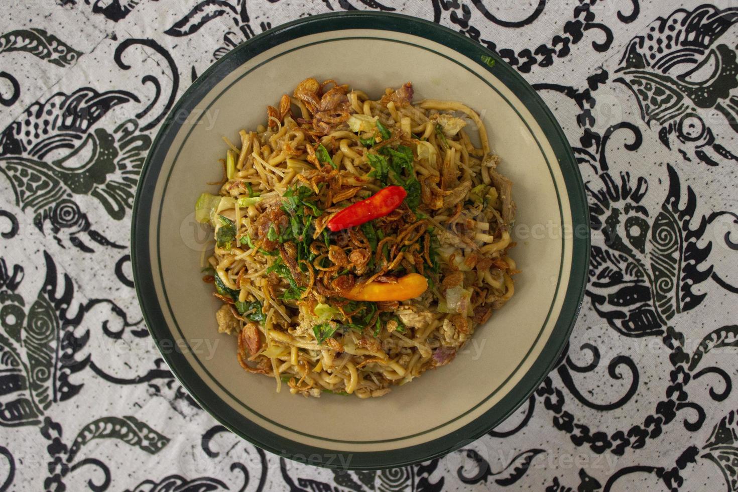 Mie Goreng Jawa or bakmi jawa or java noodle with spoon and fork. Indonesian traditional street food noodles from central java or Yogyakarta, indonesia on white background photo