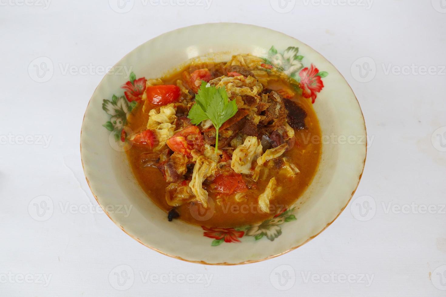 Goat Curry or gulai kambing, food from asia. Delicious goat meat curry served in a bowl.served with tomato, seasoning, celery and cabbage photo