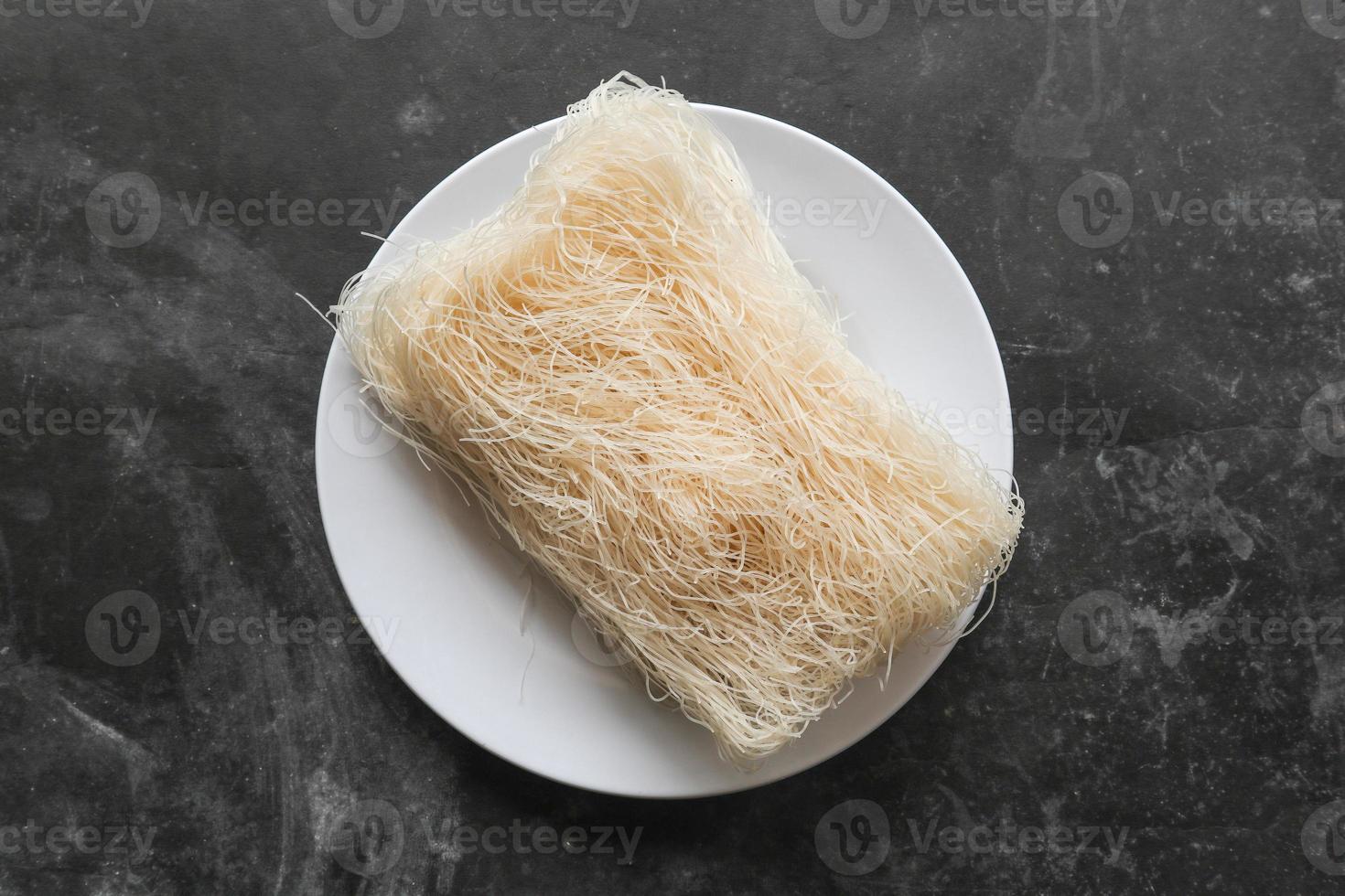 bihun seco crudo o vermicelli o fideos de arroz o cabello de ángel aislado sobre fondo blanco foto
