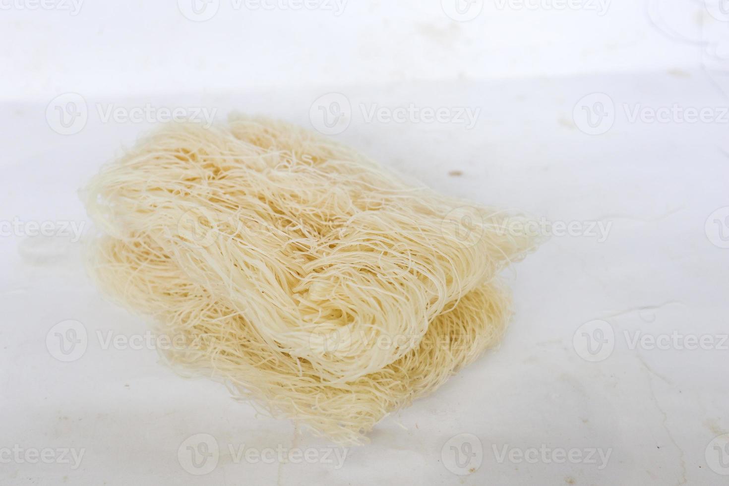 bihun seco crudo o vermicelli o fideos de arroz o cabello de ángel aislado sobre fondo blanco foto
