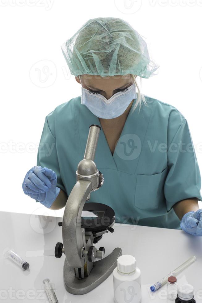 Scientist in blue medical gloves and uniform learning COVID-19 samples with microscope in laboratory. photo