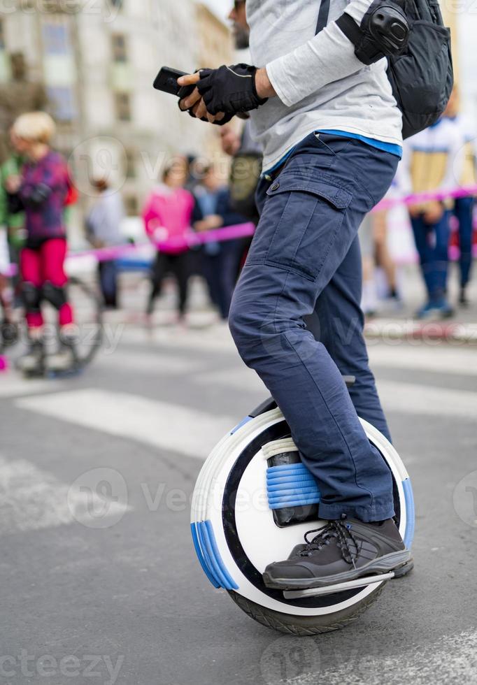 Electric unicycle. Man rides on mono wheel on zebra crossing photo