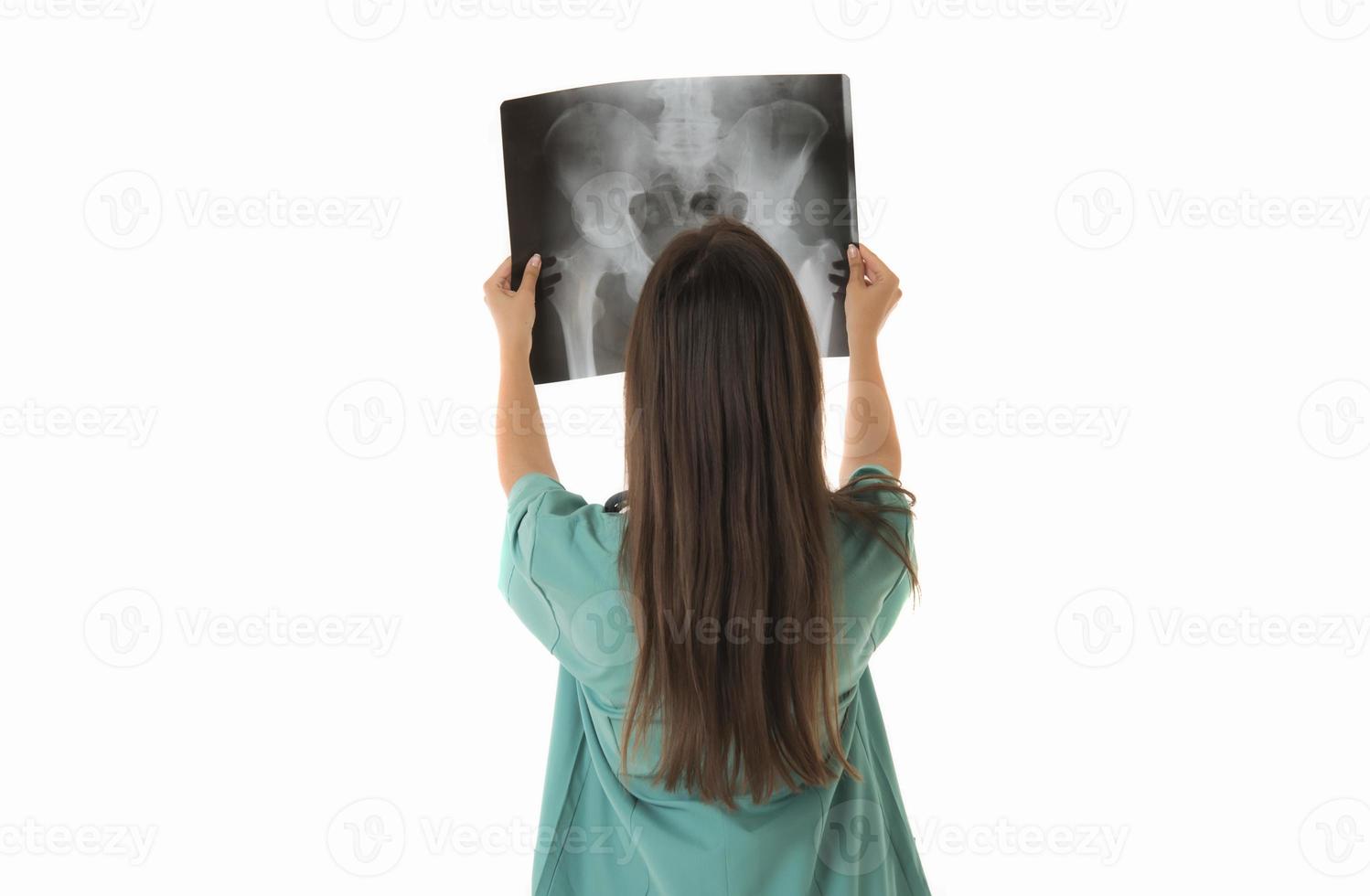 Young female doctor looking at the x-ray picture. isolated on white photo