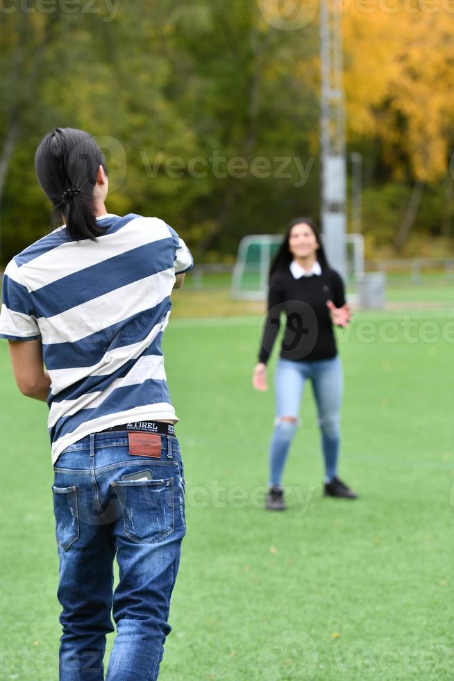 mixed Couple In Park playing American Football. American football. Couple playing Rugby. photo