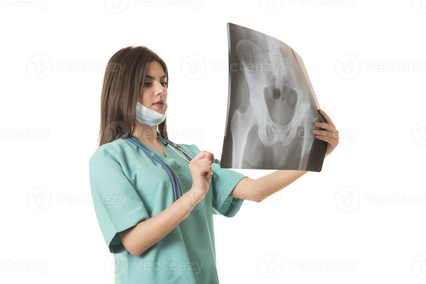 joven doctora mirando la imagen de rayos x. aislado en blanco foto
