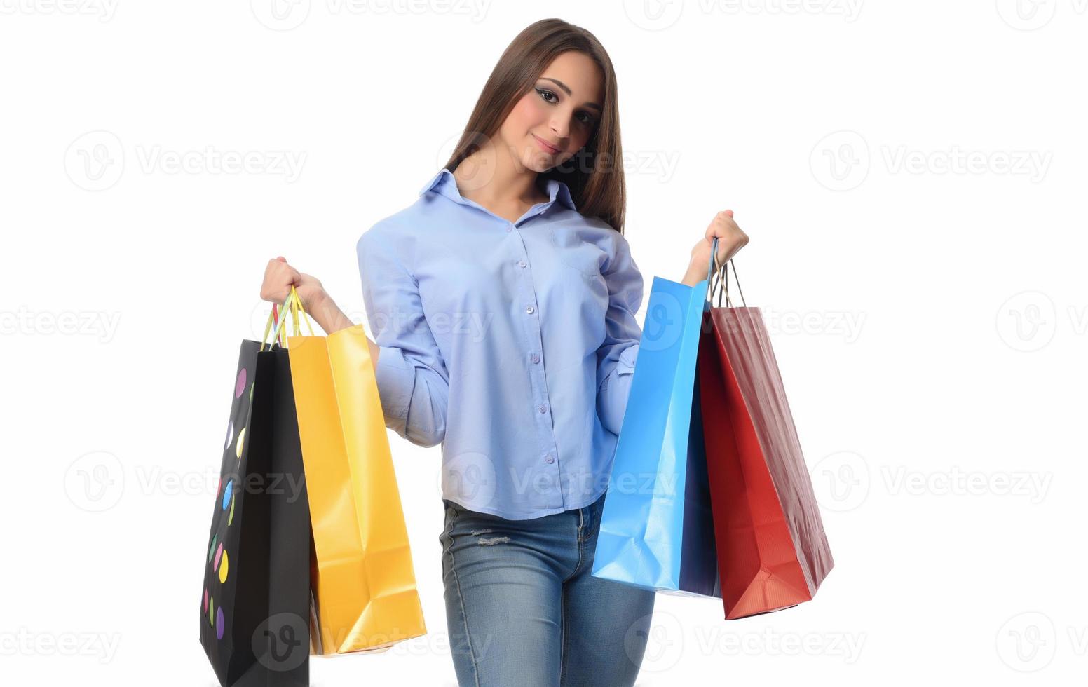 concepto de compras. hermosa morena sonriente con bolsas de compras posando sobre fondo blanco foto