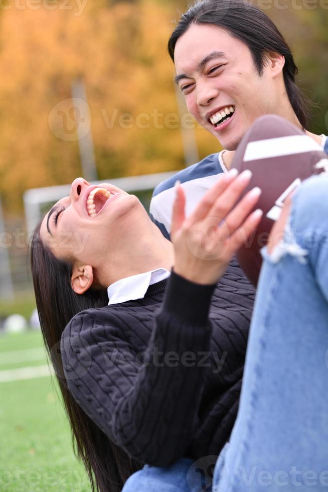 mixed Couple In Park playing American Football. American football. Couple playing Rugby. photo