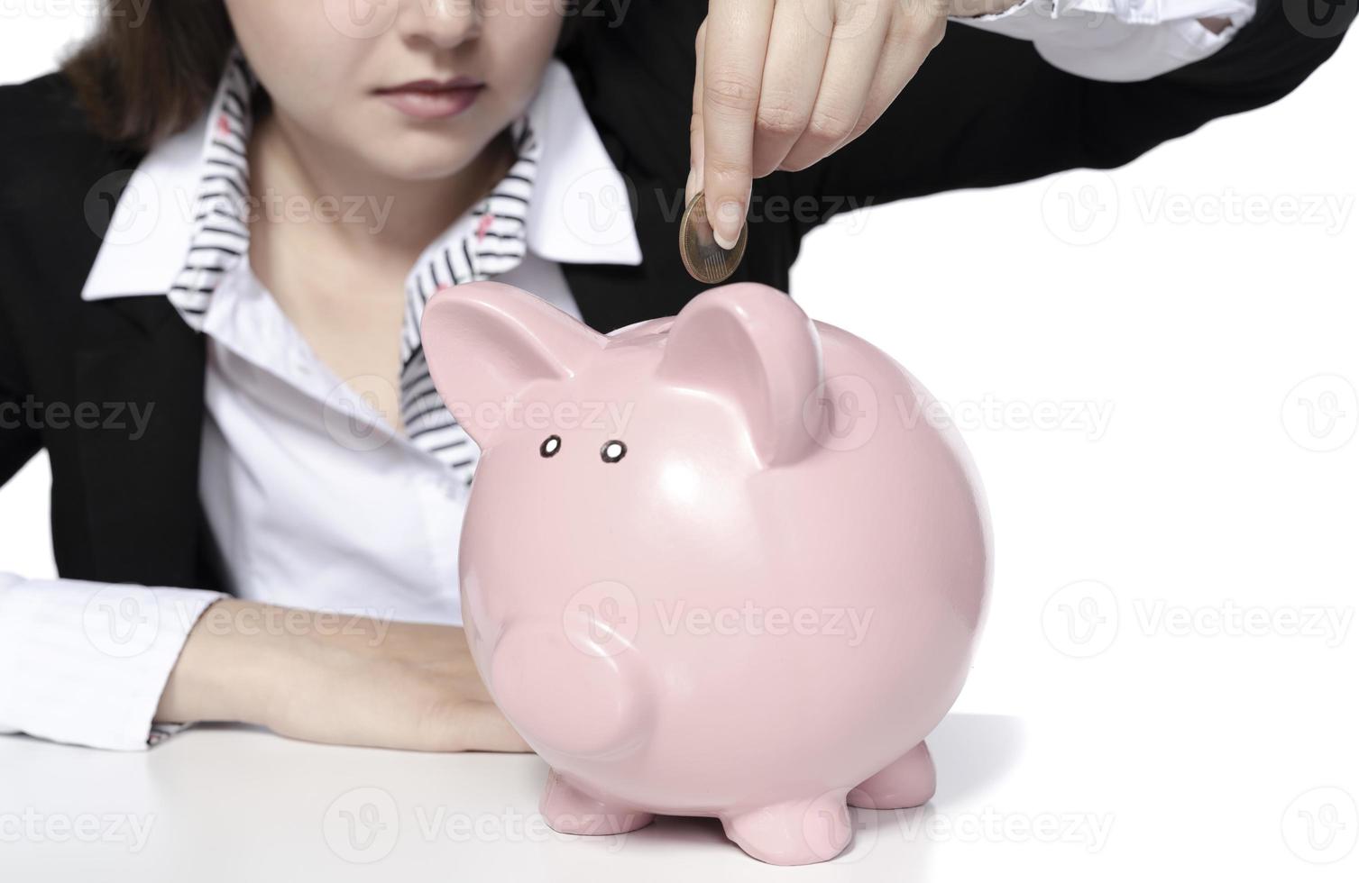 saving concept. beautiful female model saving her money in a piggy bank photo