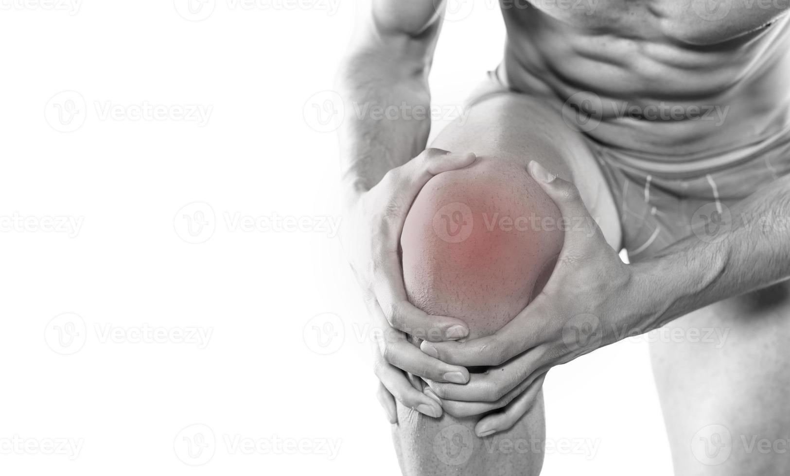 young sport man with strong athletic legs holding knee with his hands in pain after suffering ligament injury during a running workout training isolated on white background photo