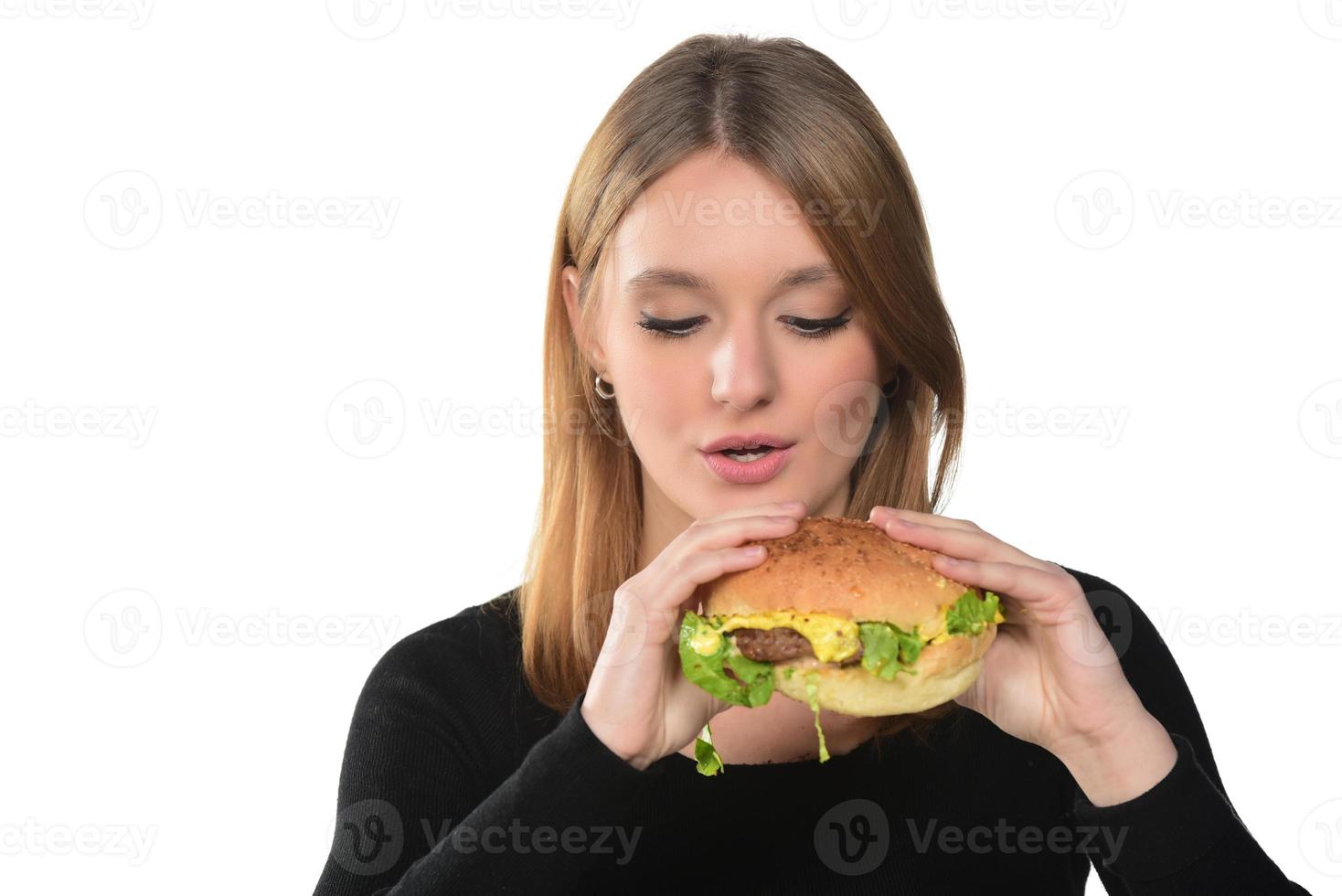 portrait of a beautiful funny young girl eating hamburger photo