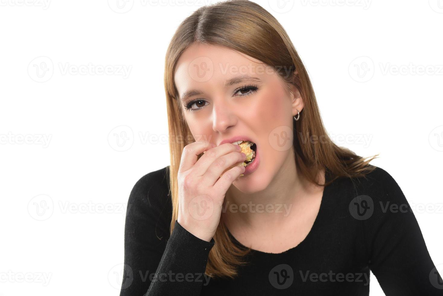 retrato de una hermosa joven divertida comiendo hamburguesas. foto