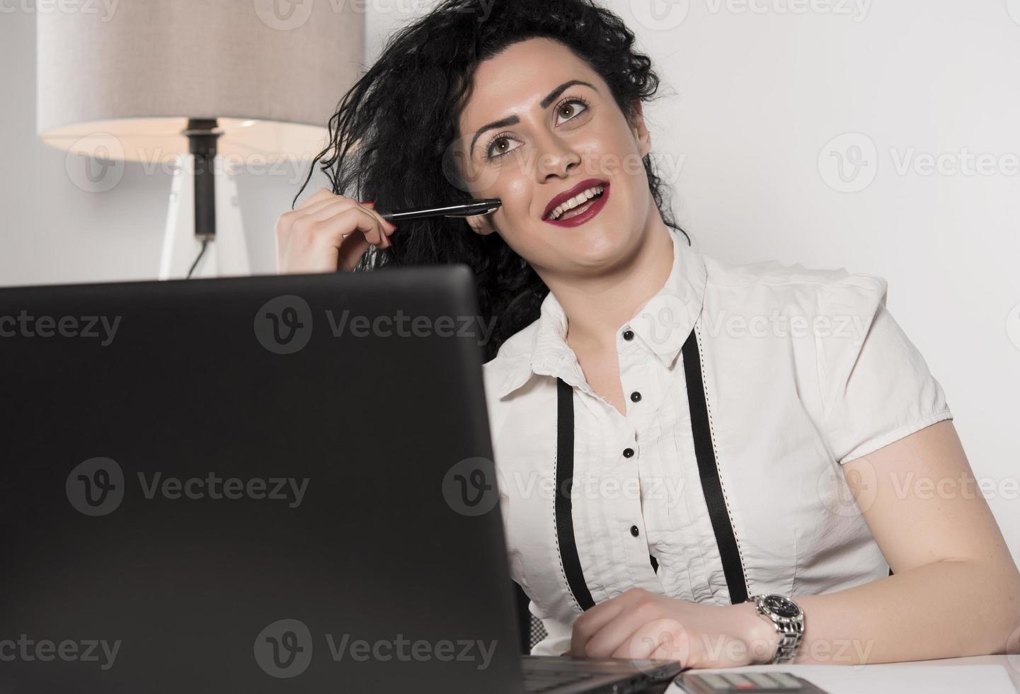 beautiful business woman sitting in her office and talking on the cellphone. business concept photo