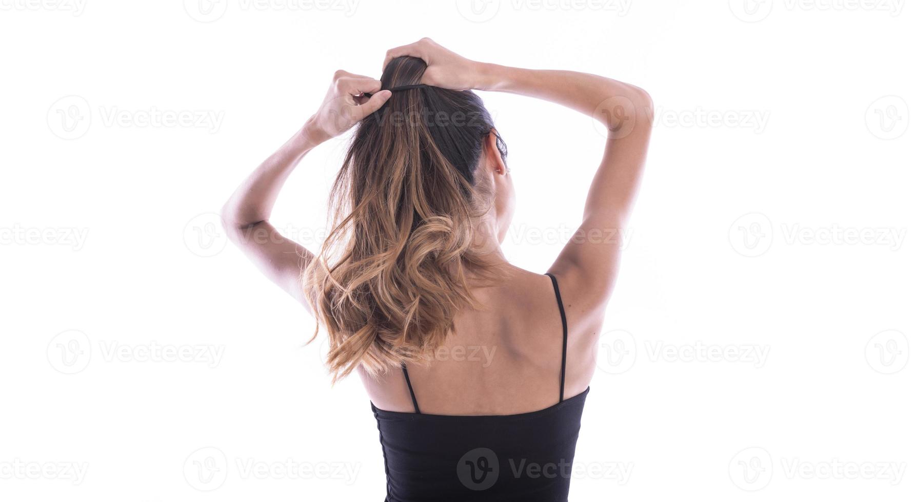 back view of young woman tied her hair in bun. isolated photo