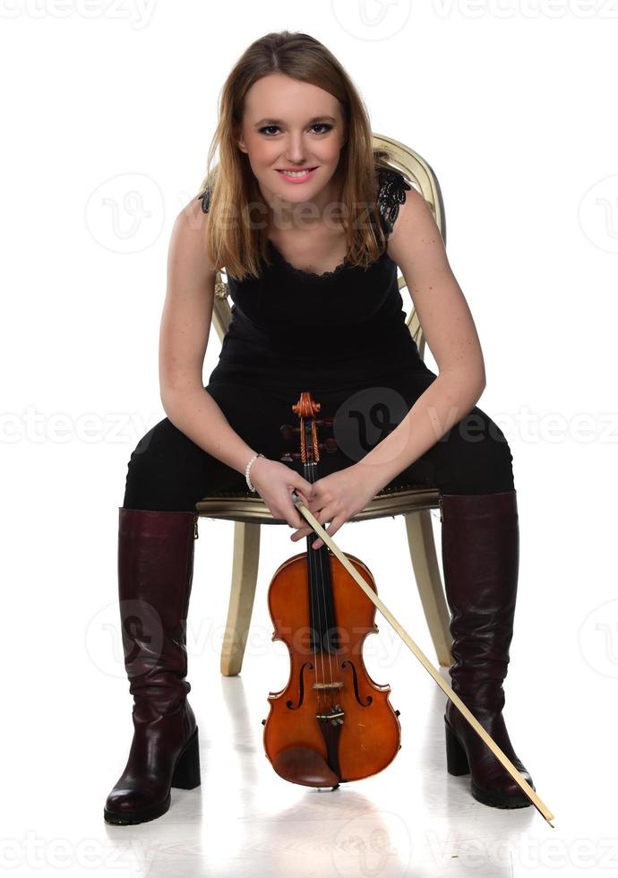 Beautiful natural blond girl holding and playing violin. photo