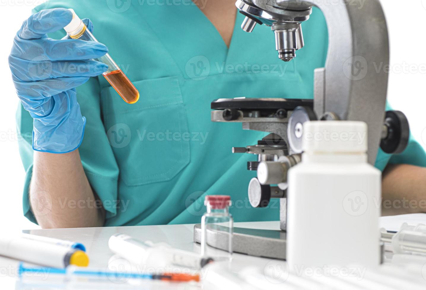 Scientist in blue medical gloves and uniform learning COVID-19 samples with microscope in laboratory. photo