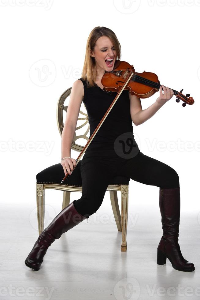 hermosa chica rubia natural sosteniendo y tocando el violín. foto