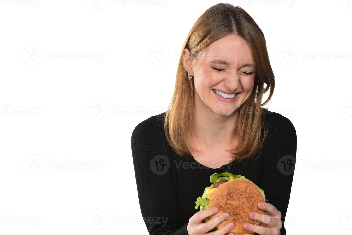 portrait of a beautiful funny young girl eating hamburger photo