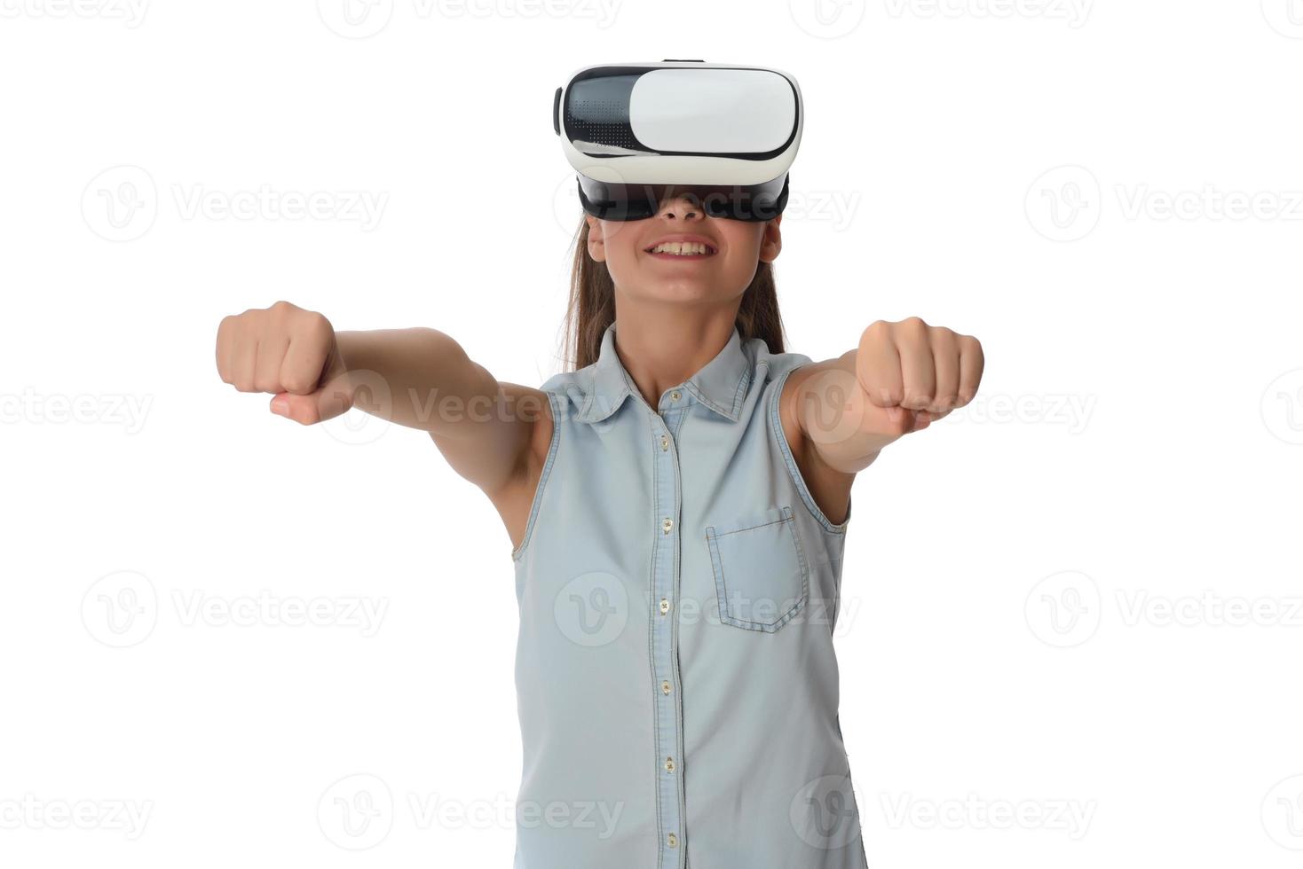 Pretty cute excited female in VR headset looking up and trying to touch objects in virtual reality photo