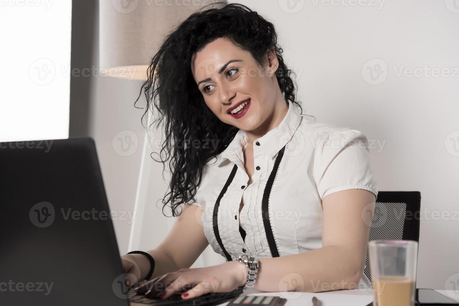 happy business woman trying to work in her office photo