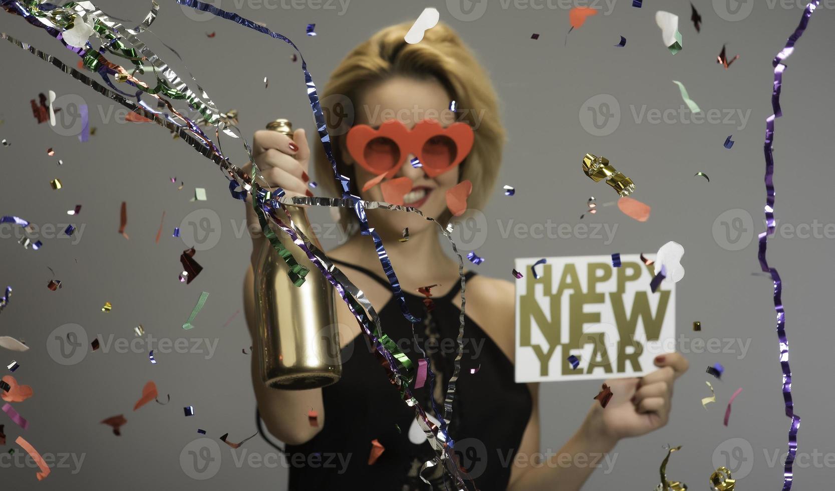 Attractive blonde women celebrating new year holding sign HAPPY NEW YEAR. isolated photo