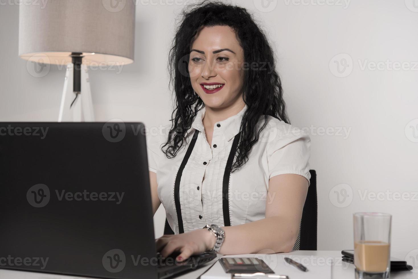 beautiful business woman sitting in her office and talking on the cellphone. business concept photo