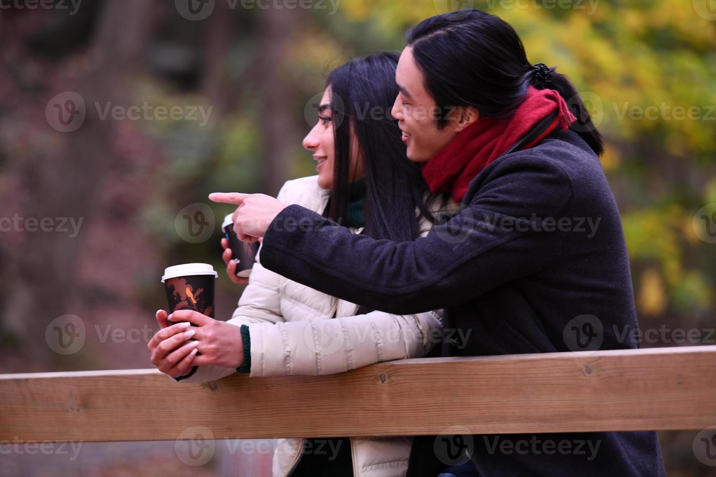 Mixed couple In park enjoying each other and drinking coffee photo