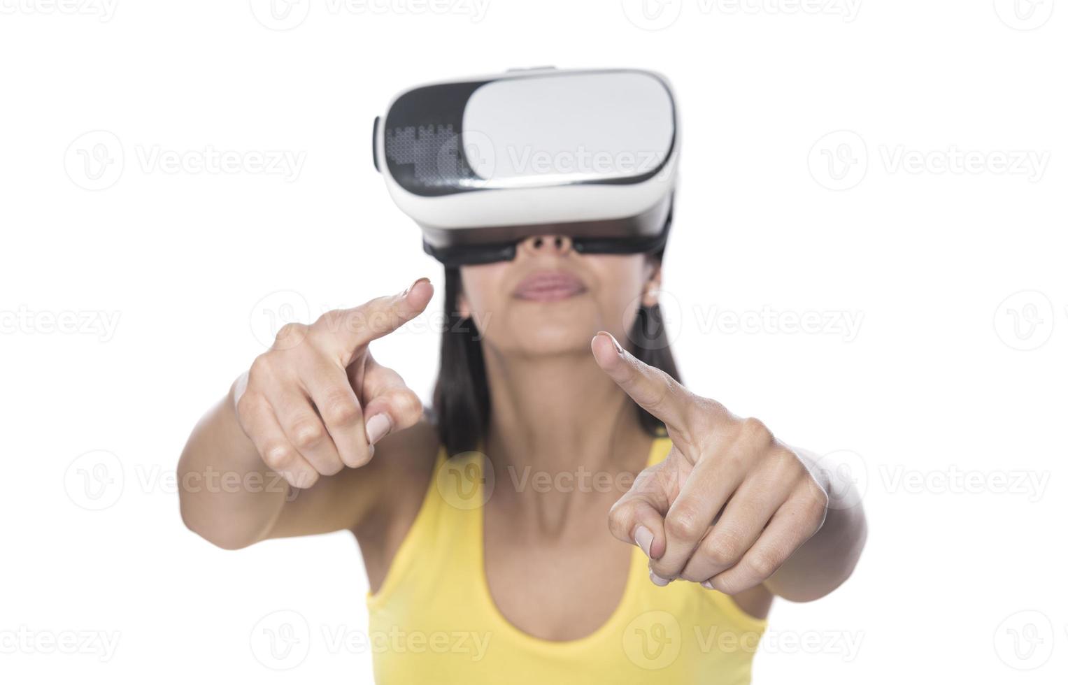 Pretty cute excited female in VR headset looking up and trying to touch objects in virtual reality photo