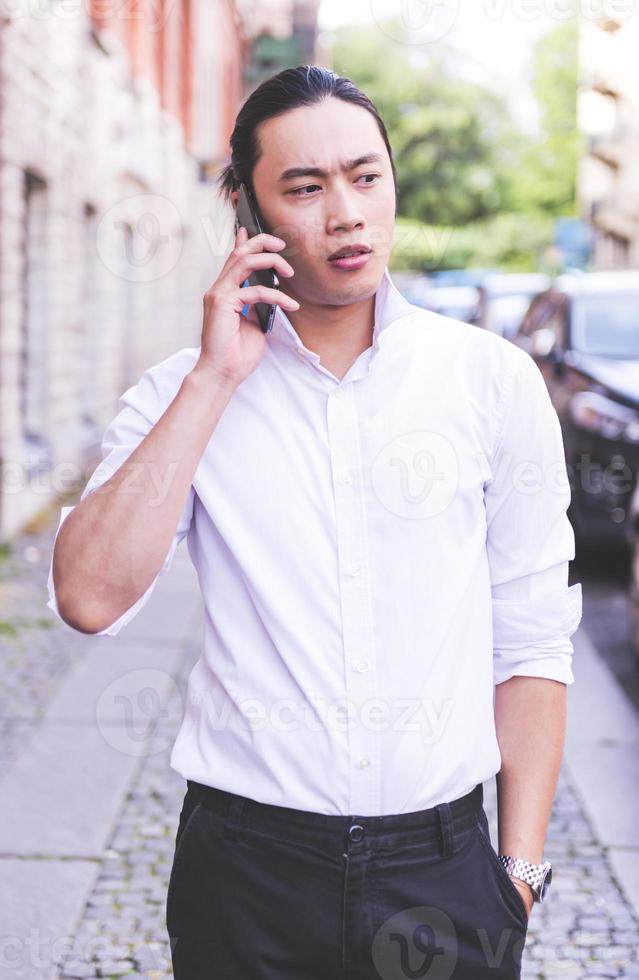 ASIAN business male model talking on his cell phone photo