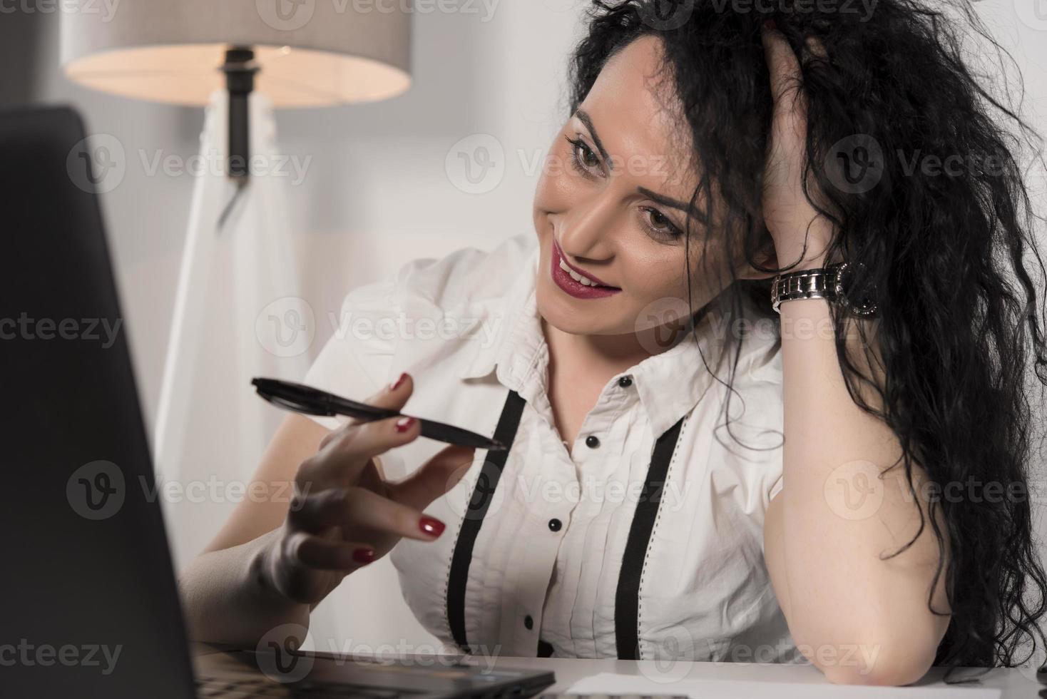beautiful business woman sitting in her office and talking on the cellphone. business concept photo
