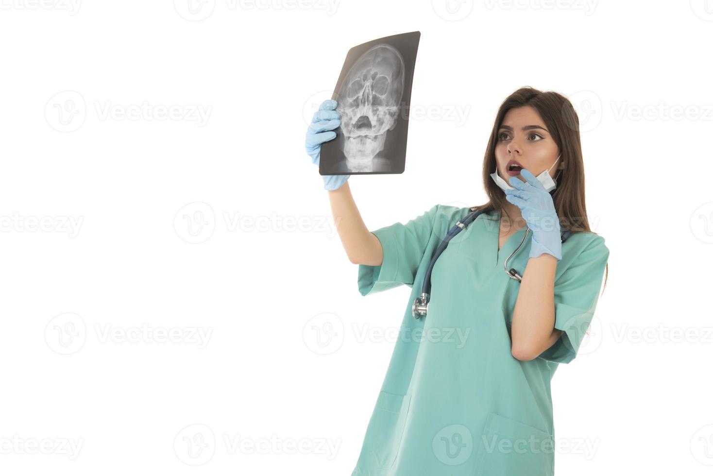 Young female doctor looking at the x-ray picture. isolated on white photo