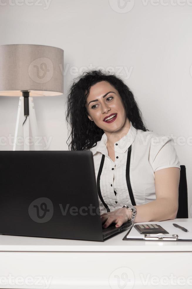 happy business woman trying to work in her office photo