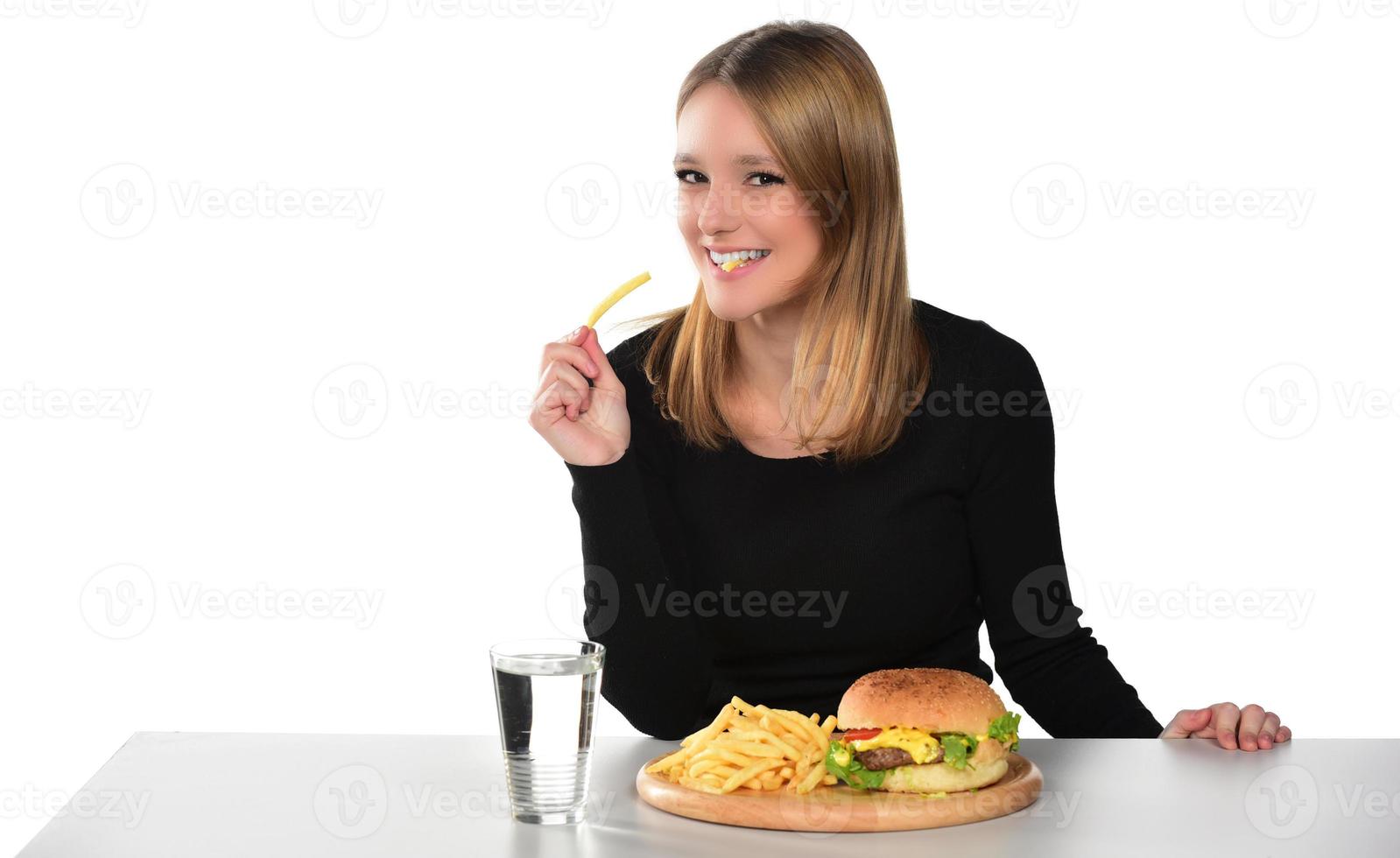 retrato de una hermosa joven divertida comiendo hamburguesa foto