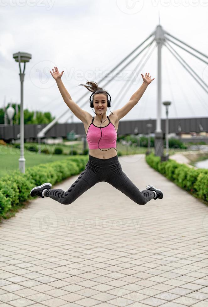 Sports woman jumping of joy till exercise. photo