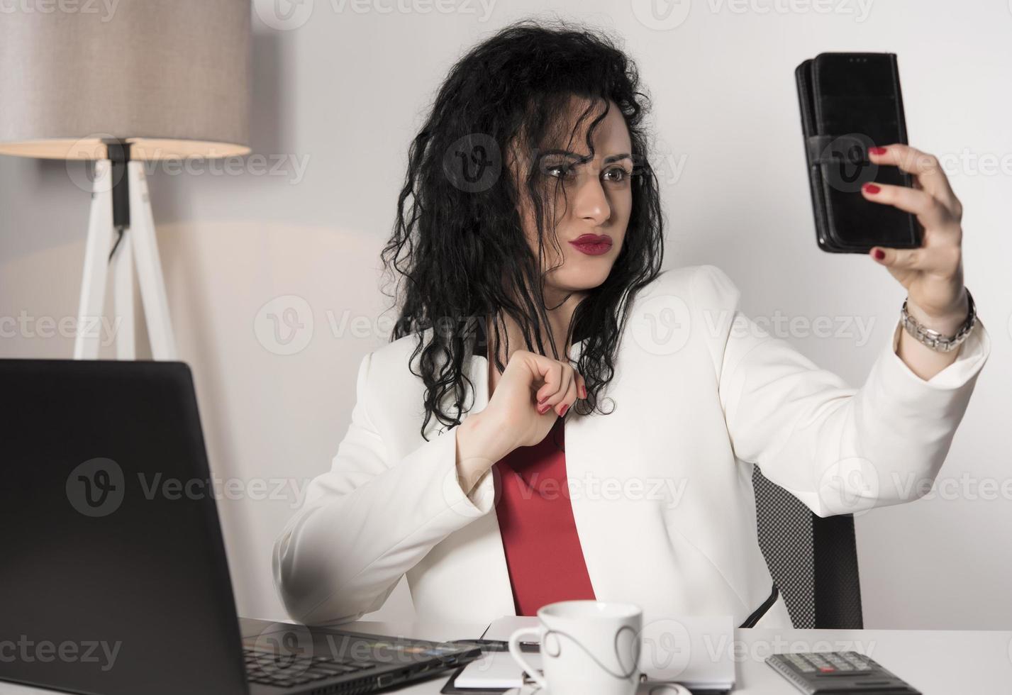 beautiful business woman sitting in her office and talking on the cellphone. business concept photo