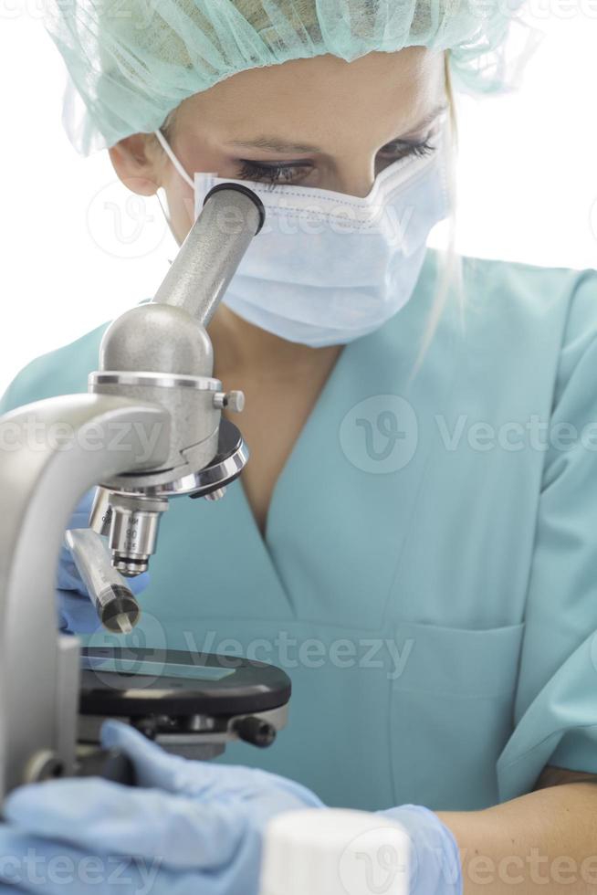 científico con guantes médicos azules y muestras uniformes de aprendizaje covid-19 con microscopio en laboratorio. foto