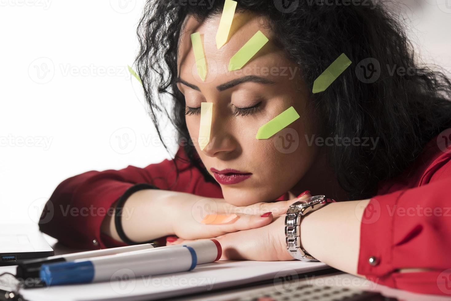 Pretty female model with a lot of post it notes working in her office. photo