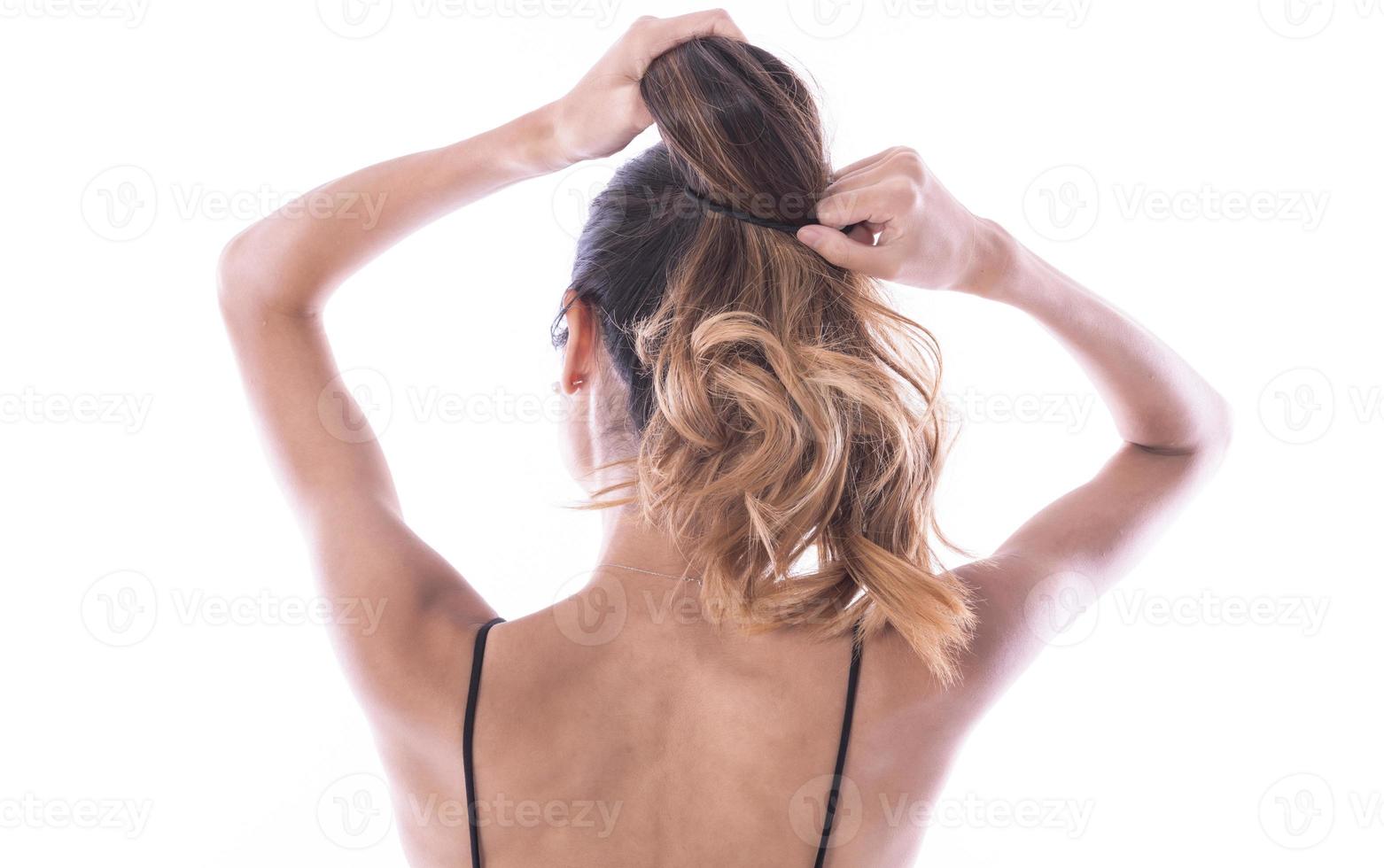 back view of young woman tied her hair in bun. isolated photo