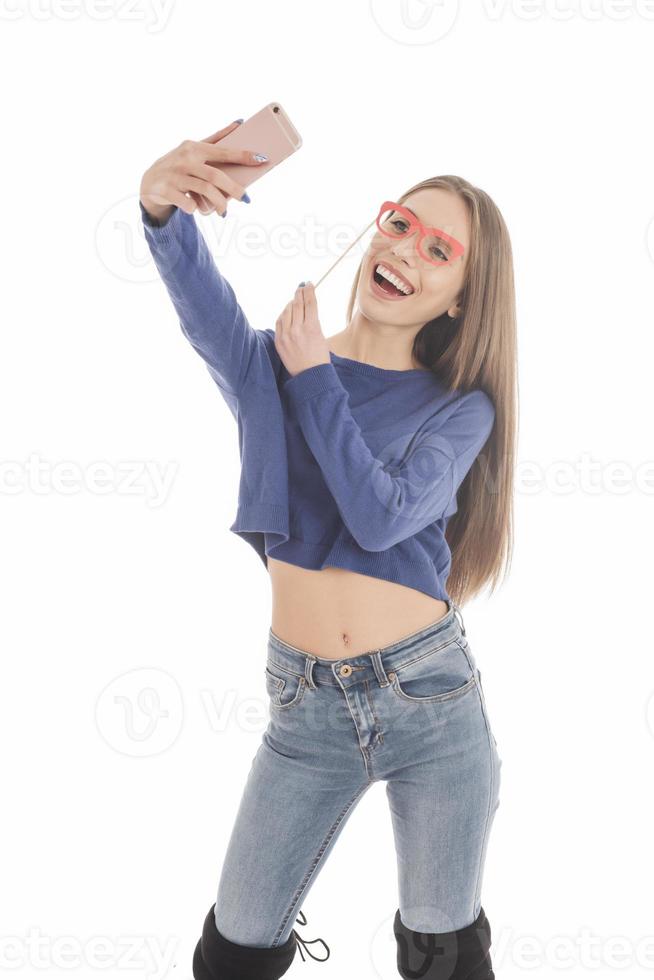 Beauty funny teenage girl making selfie with her cellphone photo