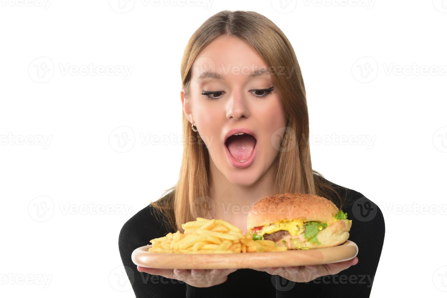 retrato de una hermosa joven divertida comiendo hamburguesa foto