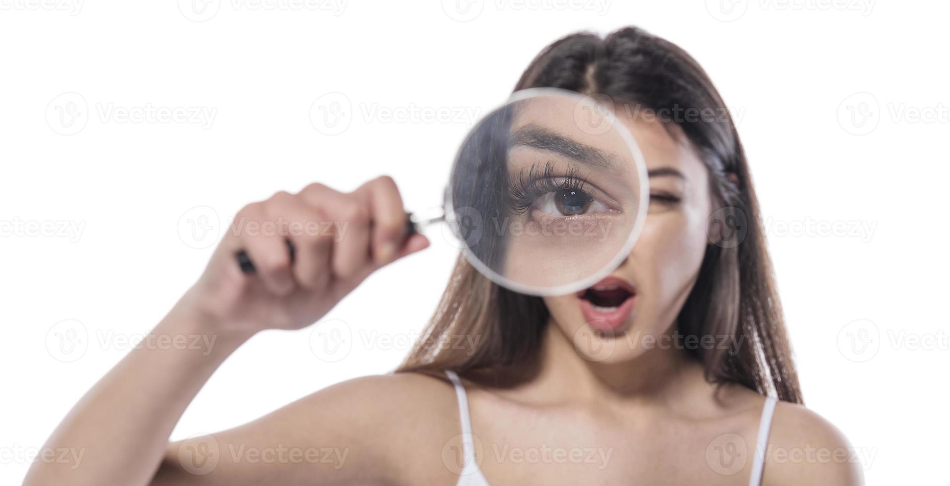attractive woman looking through magnifying glass photo