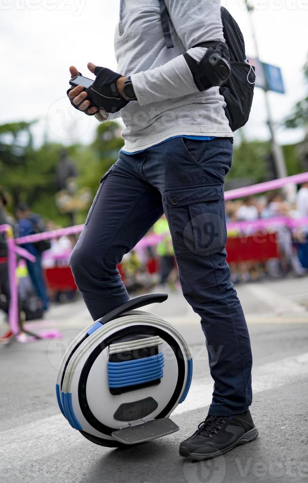 Electric unicycle. Man rides on mono wheel on zebra crossing photo